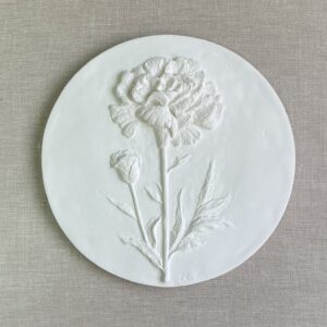Relieve blanco de un clavel en escayola, obra escultórica de temática floral sobre arte botánico